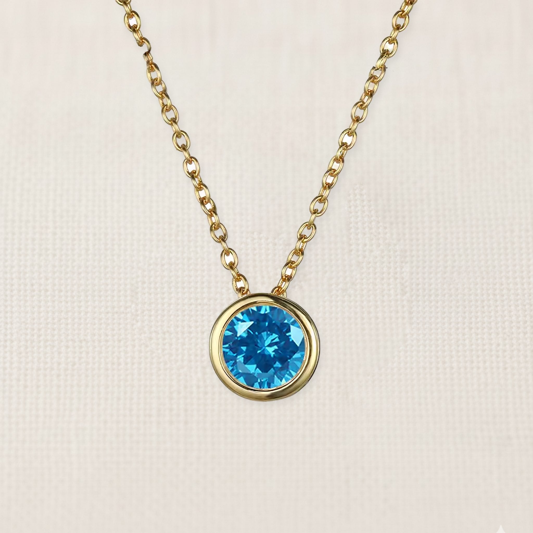 Bezelle Aurora Pendant necklace with blue topaz birthstone in 14K yellow gold