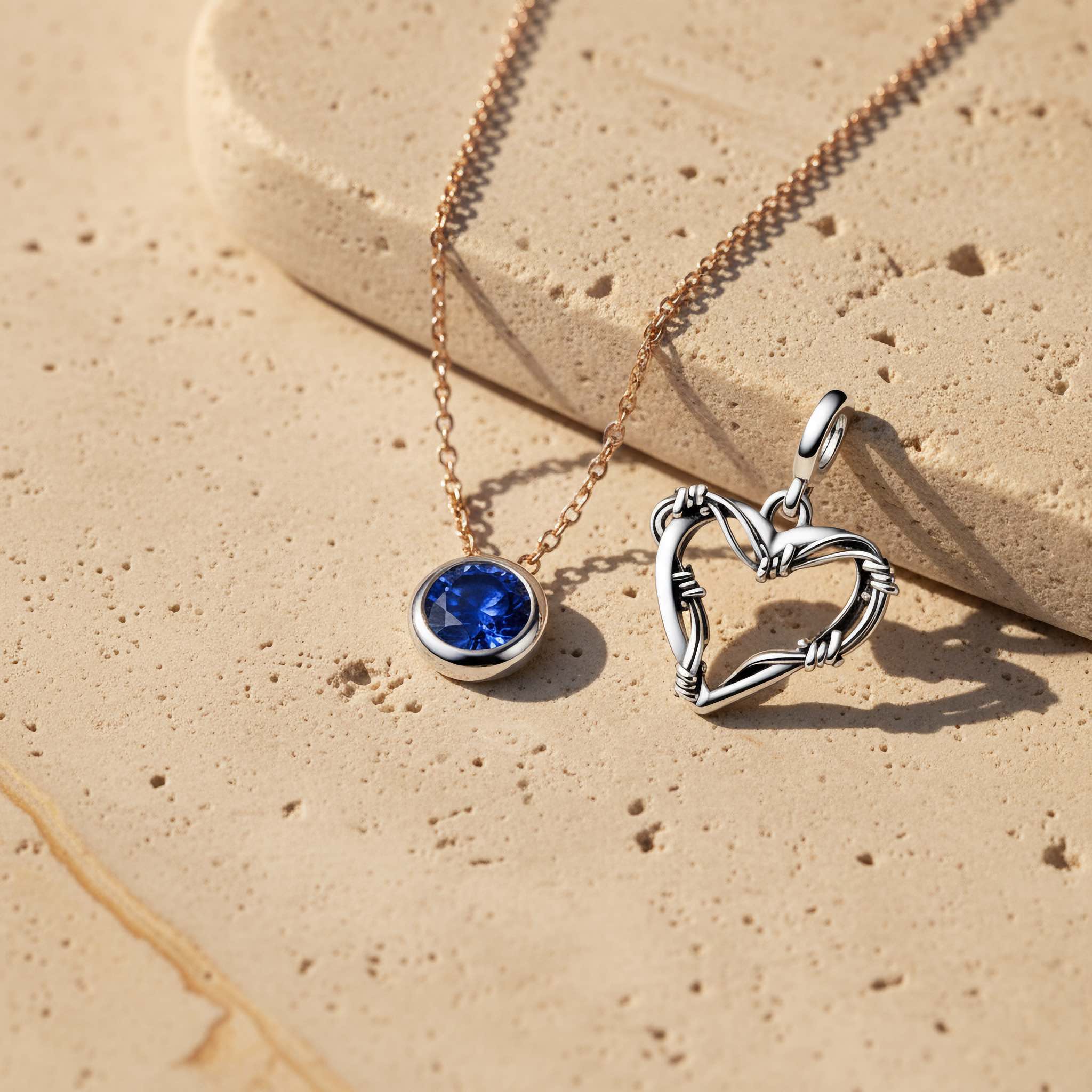 Bezelle Jewelry brand story banner showing sapphire pendant necklace, silver cable chain, and heart charm close-up.