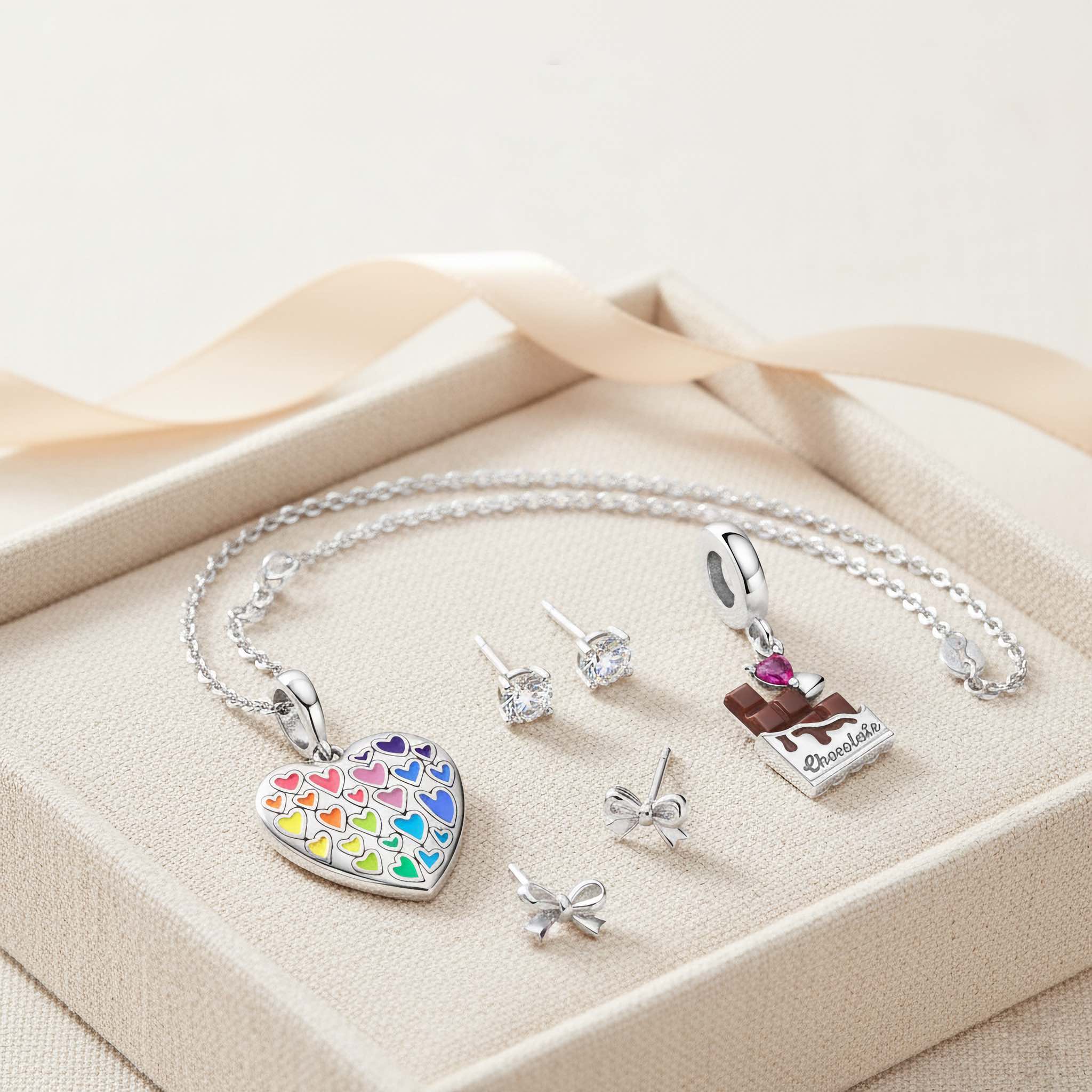 Bezelle Jewelry gifts under $150 banner with silver birthstone studs, heart charm, pumpkin charm, and fine cable chain.